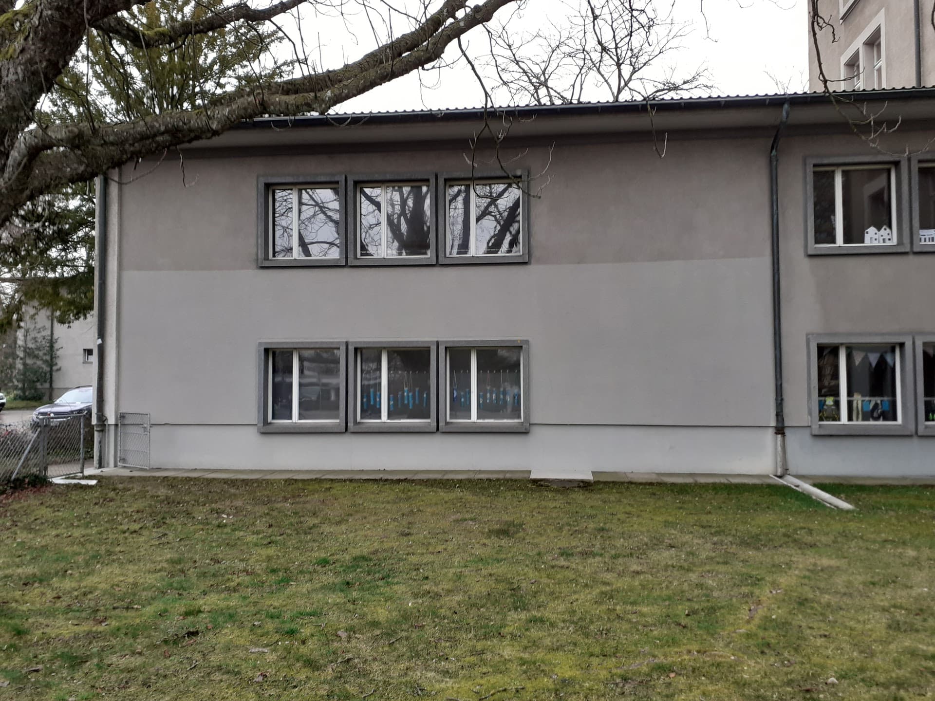 Haus mit Regenrinne, die in eine Wiese geleitet wird.